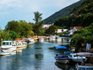 Fototapeta na wymiar Small boats parking on river near hillside