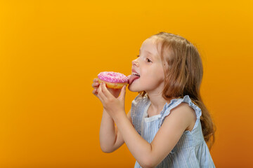 Close-up portrait of a happy pretty girl eating donuts.