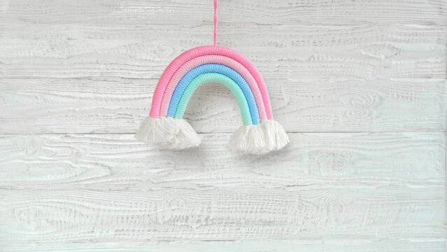 Soft Cotton Rainbow Toy on a Wooden White Wall. Baby Child Mockup for Design Presentation, Minimal Composition. Free Space For Text. Boho Kids Decoration. Accessories for Birthday Party. Macrame Knit