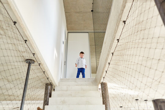 Kleiner Junge steht vor den Stufen einer steilen Treppe