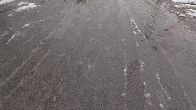 Asphalt road surface covered with sleet during a snowfall