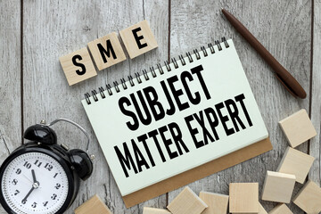 SME . text on white paper. near the table clock.