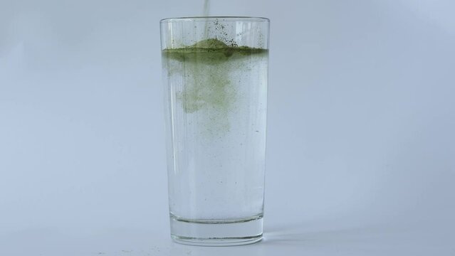 Green Vitgrass powder dissolved in a glass of water