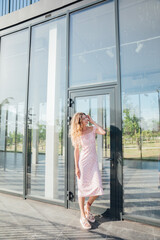 a woman stands at the glass door of a building