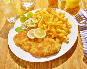 Wiener Schnitzel mit Pommes Frites im Freien mit Sonne
