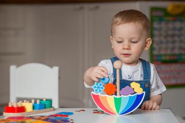 Balancing toys. A little boy is playing educational games. Children's wooden toy in the form of an...