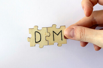 The acronym DM, which stands for Direct Message. The letters written on the puzzles.