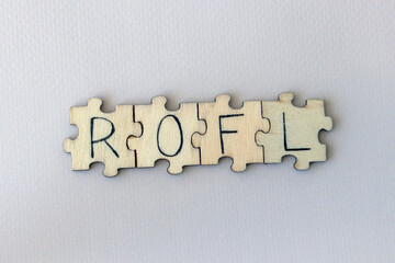 Obraz premium The acronym ROFL, which stands for Rolling On the Floor Laughing. The letters written on the puzzles.
