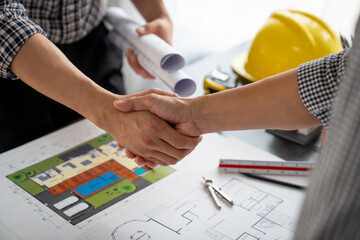 Architect and construction worker engineers shaking hands while teamwork and cooperation concept after completion of agreement on village construction project Successful Collaboration Concept.
