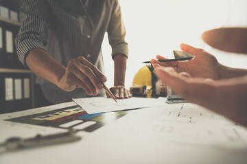 Architects, engineers, contractors discuss construction plans, site work, layout design. Plans on...