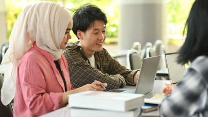 University students collaborating on a project in campus. Education, Learning and technology concept