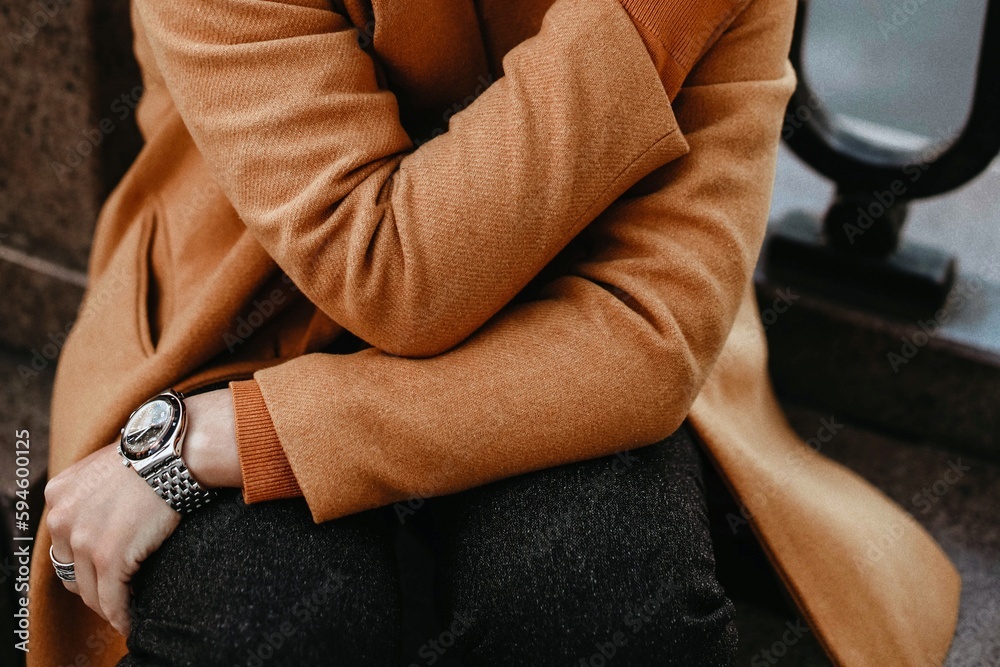 Sticker Details of orange warm cozy female coat and hand with accessories. Outdoor portrait. Autumn winter street style cloth collection