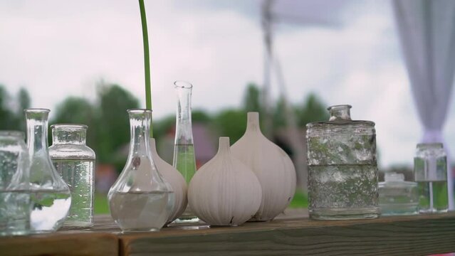 Glass transparent flower vases with water on the table. Preparation for holiday, party, wedding reception.