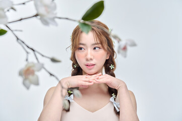 Beautiful Young Asian woman behind flower in beauty pose. Pretty girl in white background. 
sexy...