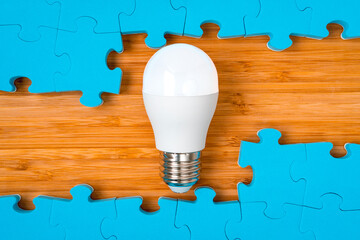 Blue puzzle frame with a bright light bulb in the middle