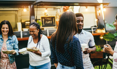 Multiracial people having fun drinking in front of food truck outdoor - Focus on center girl head
