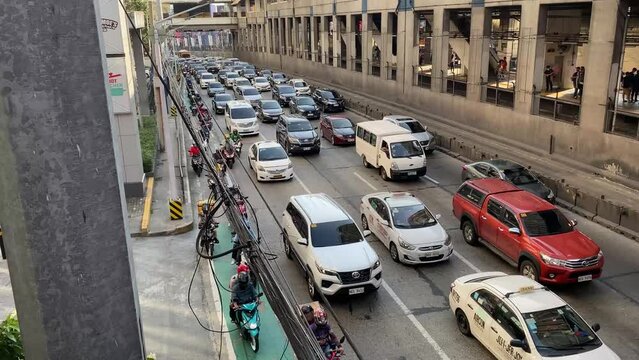 Manila, Philippines - April 18, 2023: Slow-moving cars and vehicles along a four-lane highway due to traffic congestion