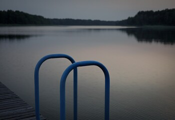 dock with bars near body of water at dusk in landscape