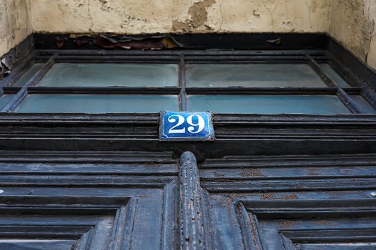 Close-up of a n old door with a number 29 sign on the front