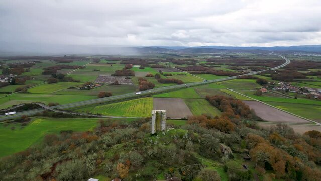 Sandiás tower near highway in ourense, spain, aerial orbit, cloudy day