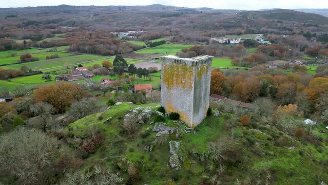 Sandiás tower of ourense, spain, aerial orbit around hillside and farmland