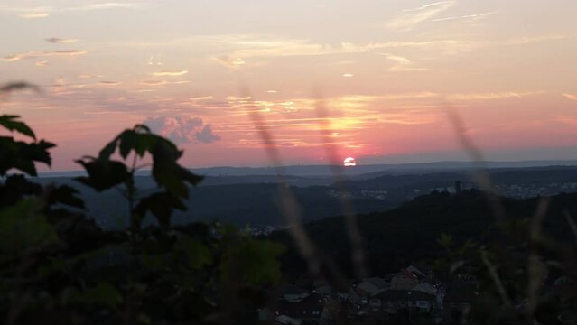 timelapse of the sunset over Forbach, France. The camera captures the changing colors of the sky as the sun sets behind the Schlossberg Castle