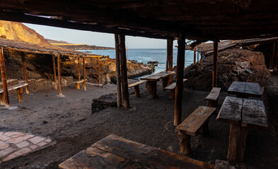 Fototapeta na wymiar Recreational area for barbecues at sunset on the beach of Tacoron in El Hierro, Canary Islands