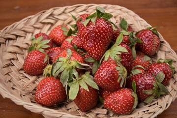 Fresh sweet red strawberries with leaf in the bamboo bucket