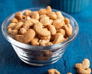 Tasty cashew nuts in a bowl on wooden table. Close-up.