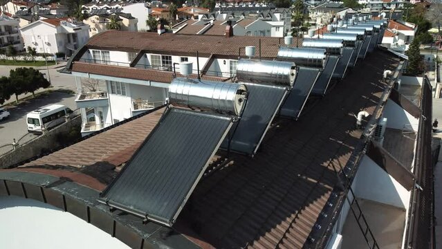 Aerial view water tanks and solar batteries on house roof, steel barrels of boilers, Water heating by sun and solar panels, saving electricity, solar energy, eco tube collector sun panel.