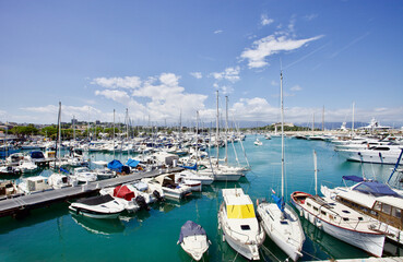 Yachts and speed boats at harbor. Yachts moored in the port. Ocean Coast pier. High class lifestyle. Yachting. Expensive toys. Sea ​​transport. Nautical. Yachting sport. Expensive yachts at the pier.