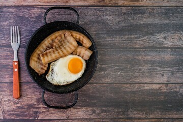 a skillet with eggs, bacon, bread, toast, and fork on a