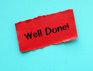 red paper on blue background with handwritten text WELL DONE, concept of compliment praise giving to someone to tell they doing great work or awesome job, positive affirmation to boost self esteem