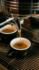 shot of hot espresso coffee is pulled through portafilter with wooden handle into clear glass. Process of making coffee