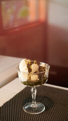 vanilla ice cream in an aesthetic cup with brown sugar crumble and caramel syrup on top