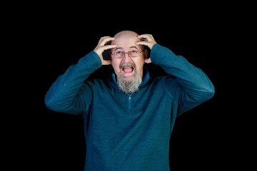 Middle-aged man suffering from a severe headache or migraine, isolated on black background