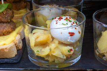 Close-up photo of a typical tapa or aperitif served in a Spanish bar, potatoes and a fried egg...