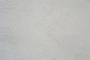 A white wall with a rough textured surface.