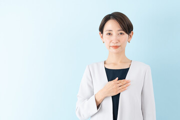 笑顔で胸に手を添えるビジネスウーマン