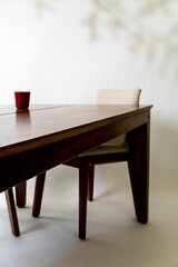 Selective focus on a wooden table in a modern living room with a white chair in the backdrop