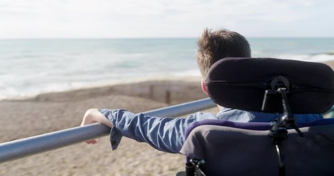 MS PAN Portrait of disabled teenage boy looking at sea view