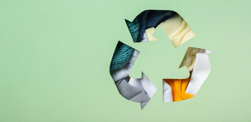 Colorful clothes under paper cut recycling symbol. Second hand, fast fashion, slow fashion concept....