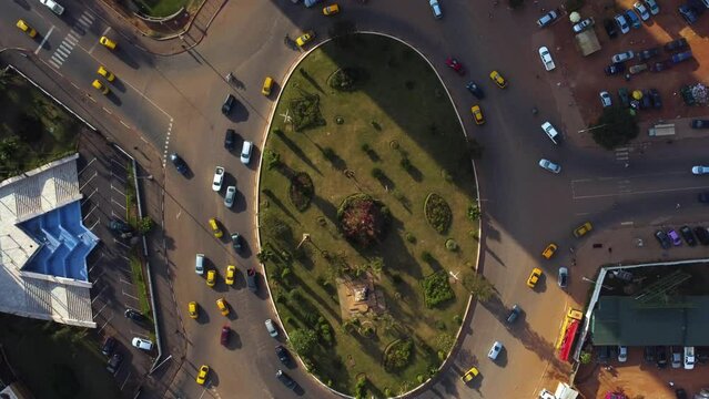 Aerial view above traffic at a roundabout, in sunny Yaounde, Cameroon - cenital, drone shot