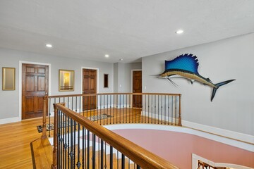 Modern and well-maintained home features a staircase with banisters and railings in New England