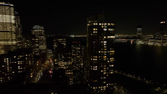 Ascending aerial view in front of the Tribeca Pointe and schools in Battery park city, night in New York