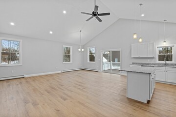 Empty kitchen with lots of white cabinets and a ceiling fan