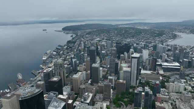 High aerial view pulling away from Seattle gloomy downtown skyscrapers.