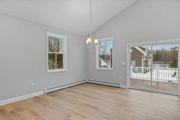 Empty room with two windows and wood flooring