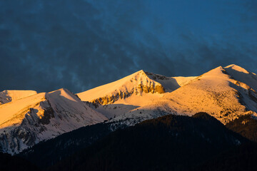 Snow covered Pirin mountains at sunrise. View from Bansko town.