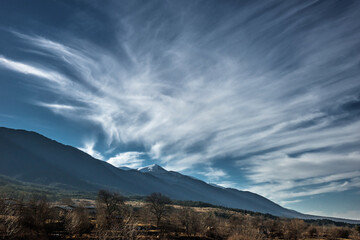 Late autumn landscape in Bansko. Cirrus clouds above fields at the foot of Pirin mountains.